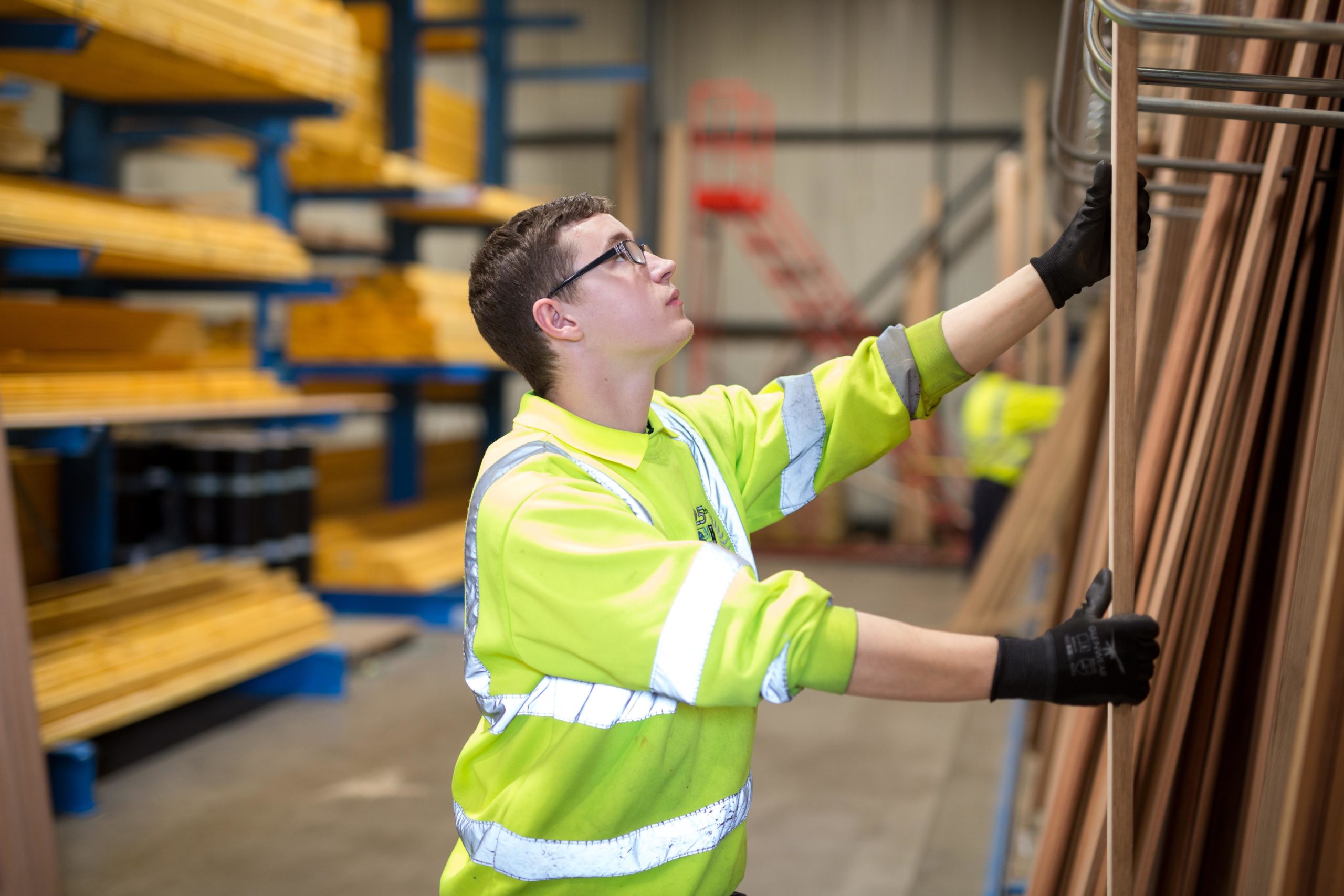 Donaldson Group Employee stacking wood products in a warehouse